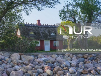 An old Danish wooden house with a thatched roof is on the seashore in Kongebro Middelfart, Fyn, Denmark, on May 3, 2024. (