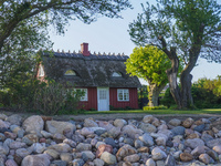 An old Danish wooden house with a thatched roof is on the seashore in Kongebro Middelfart, Fyn, Denmark, on May 3, 2024. (