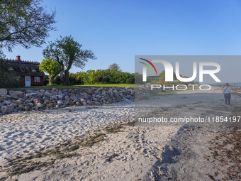 An old Danish wooden house with a thatched roof is on the seashore in Kongebro Middelfart, Fyn, Denmark, on May 3, 2024. (