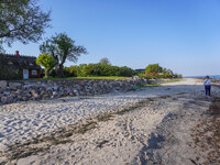 An old Danish wooden house with a thatched roof is on the seashore in Kongebro Middelfart, Fyn, Denmark, on May 3, 2024. (