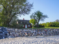 An old Danish wooden house with a thatched roof is on the seashore in Kongebro Middelfart, Fyn, Denmark, on May 3, 2024. (