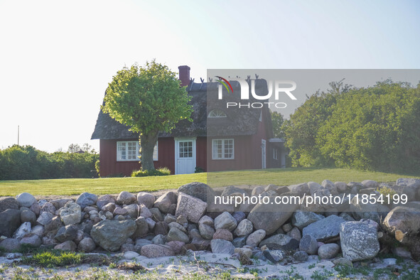 An old Danish wooden house with a thatched roof is on the seashore in Kongebro Middelfart, Fyn, Denmark, on May 3, 2024. 