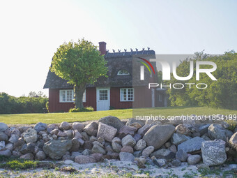 An old Danish wooden house with a thatched roof is on the seashore in Kongebro Middelfart, Fyn, Denmark, on May 3, 2024. (