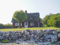 An old Danish wooden house with a thatched roof is on the seashore in Kongebro Middelfart, Fyn, Denmark, on May 3, 2024. (