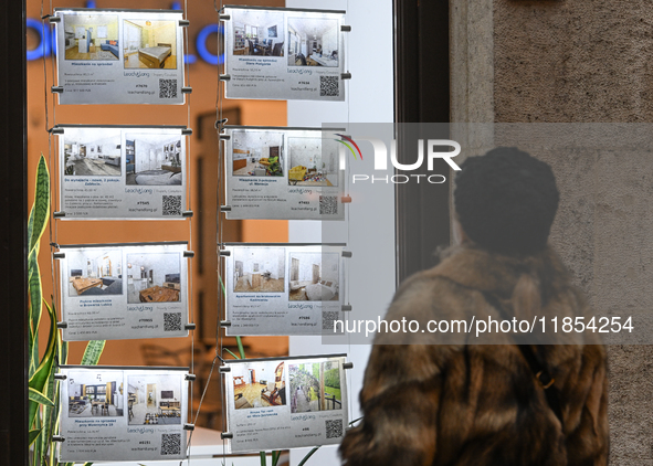 KRAKOW, POLAND - DECEMBER 10:   
A woman looks at a window displaying advertisements for properties at a local real estate office in the his...