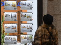 KRAKOW, POLAND - DECEMBER 10:   
A woman looks at a window displaying advertisements for properties at a local real estate office in the his...