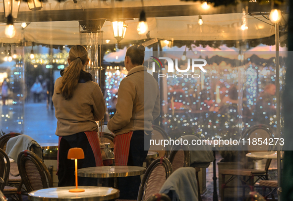 KRAKOW, POLAND - DECEMBER 10:   
Two waitresses wait for customers inside a restaurant terrace on Krakow’s UNESCO-listed Market Square, on D...