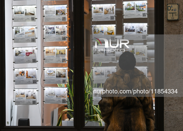 KRAKOW, POLAND - DECEMBER 10:   
A woman looks at a window displaying advertisements for properties at a local real estate office in the his...