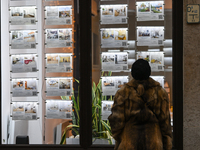 KRAKOW, POLAND - DECEMBER 10:   
A woman looks at a window displaying advertisements for properties at a local real estate office in the his...