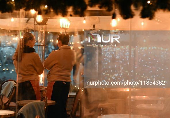 KRAKOW, POLAND - DECEMBER 10:   
Two waitresses wait for customers inside a restaurant terrace on Krakow’s UNESCO-listed Market Square, on D...