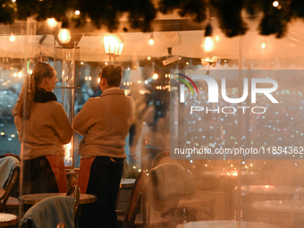 KRAKOW, POLAND - DECEMBER 10:   
Two waitresses wait for customers inside a restaurant terrace on Krakow’s UNESCO-listed Market Square, on D...