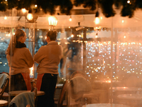 KRAKOW, POLAND - DECEMBER 10:   
Two waitresses wait for customers inside a restaurant terrace on Krakow’s UNESCO-listed Market Square, on D...