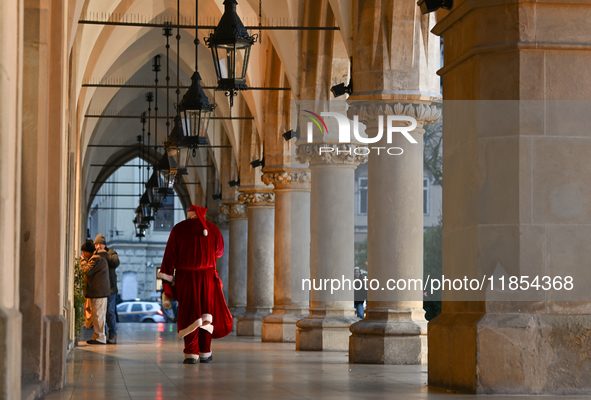 KRAKOW, POLAND - DECEMBER 10:   
A Santa busker walks through the Cloth Hall in Krakow’s UNESCO-listed Market Square, on December 10, 2024 i...