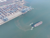 A cargo ship departs from the port after being loaded at Qinzhou Automated Container Terminal in Beiwan Port, South China's Guangxi Zhuang A...