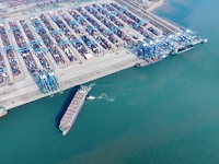 A cargo ship departs from the port after being loaded at Qinzhou Automated Container Terminal in Beiwan Port, South China's Guangxi Zhuang A...