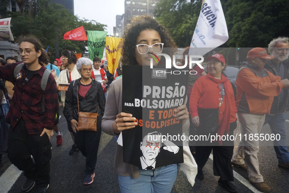 Demonstrators hold banners demanding the imprisonment of Brazilian former President Jair Bolsonaro during a protest in defense of democracy...