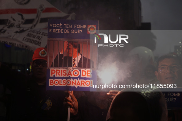 Demonstrators hold banners demanding the imprisonment of Brazilian former President Jair Bolsonaro during a protest in defense of democracy...