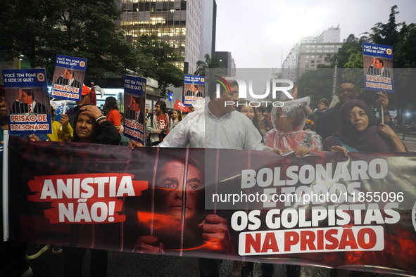 Demonstrators hold banners demanding the imprisonment of Brazilian former President Jair Bolsonaro during a protest in defense of democracy...