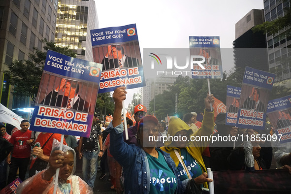 Demonstrators hold banners demanding the imprisonment of Brazilian former President Jair Bolsonaro during a protest in defense of democracy...