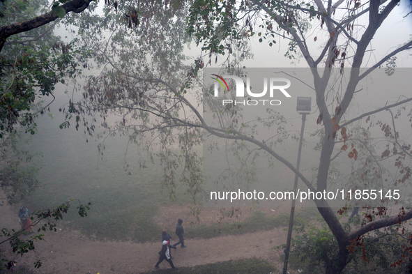 People exercise in the morning on a ground during a cold, foggy day in Siliguri, India, on December 11, 2024. 