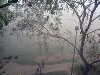 People exercise in the morning on a ground during a cold, foggy day in Siliguri, India, on December 11, 2024. (