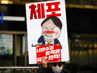 A protester holds a sign reading 'Arrest Traitor Yoon Suk-yeol, Impeach Immediately' during a solo demonstration in front of the People Powe...