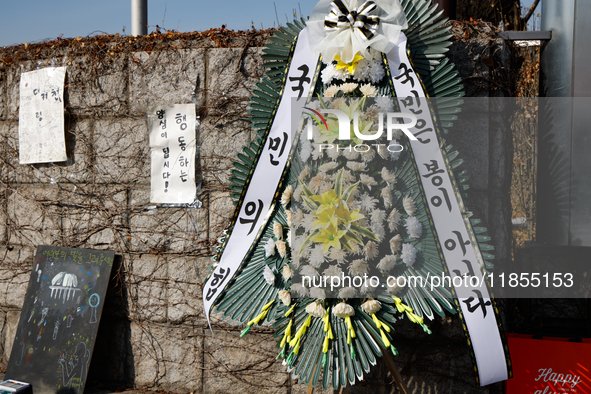 A condolence wreath with the message 'People Power Party, the people are not fools' is placed at the main gate of the National Assembly in Y...