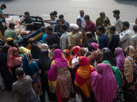 People wait in a long queue to buy government-subsidized food in Dhaka, Bangladesh, on December 10, 2024. (