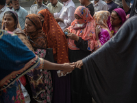 People wait in a long queue to buy government-subsidized food in Dhaka, Bangladesh, on December 10, 2024. (