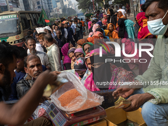 People wait in a long queue to buy government-subsidized food in Dhaka, Bangladesh, on December 10, 2024. (