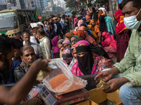 People wait in a long queue to buy government-subsidized food in Dhaka, Bangladesh, on December 10, 2024. (