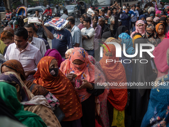 People wait in a long queue to buy government-subsidized food in Dhaka, Bangladesh, on December 10, 2024. (