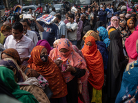 People wait in a long queue to buy government-subsidized food in Dhaka, Bangladesh, on December 10, 2024. (