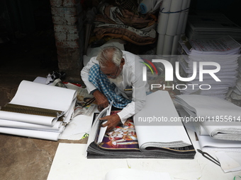 A worker makes English calendars ahead of New Year 2025 in Kolkata, India, on December 11, 2024. (