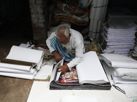 A worker makes English calendars ahead of New Year 2025 in Kolkata, India, on December 11, 2024. (