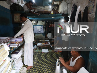 Workers make English calendars ahead of New Year 2025 at a workshop in Kolkata, India, on December 11, 2024. (