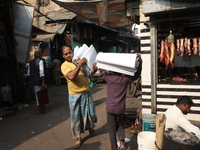 Workers carry English calendars ahead of New Year 2025, at a workshop in Kolkata, India, on December 11, 2024. (