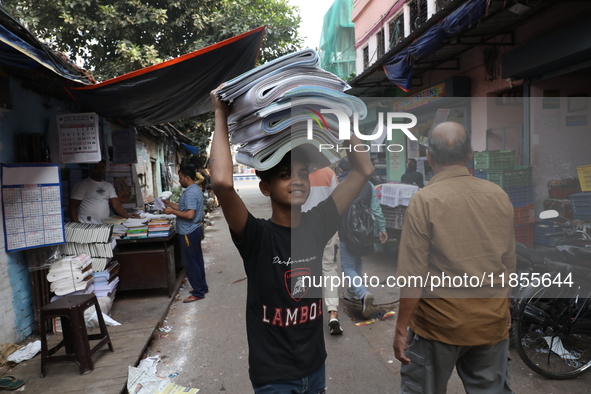 A worker carries English calendars ahead of New Year 2025 at a workshop in Kolkata, India, on December 11, 2024. 