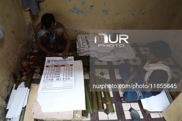 A worker makes English calendars ahead of New Year 2025 in Kolkata, India, on December 11, 2024. 