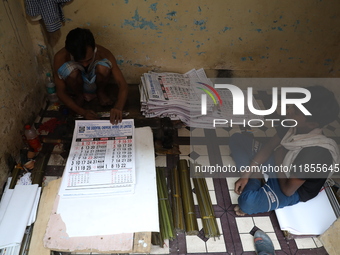 A worker makes English calendars ahead of New Year 2025 in Kolkata, India, on December 11, 2024. (