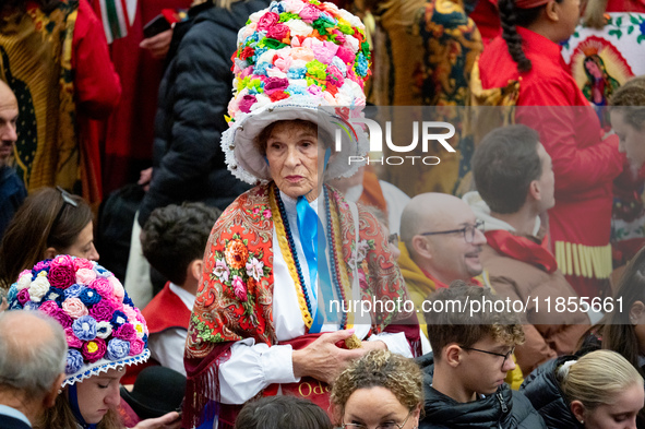 Women from a folk group wear hats with flowers as they wait for the arrival of Pope Francis during the weekly general audience at Paul-VI ha...