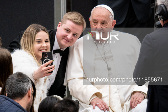 Pope Francis poses for a selfie with newlyweds at the end of the weekly general audience at Paul VI Hall in The Vatican, on December 11, 202...