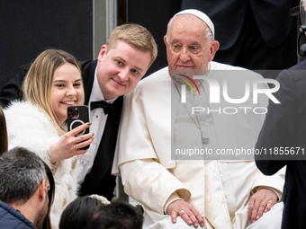 Pope Francis poses for a selfie with newlyweds at the end of the weekly general audience at Paul VI Hall in The Vatican, on December 11, 202...