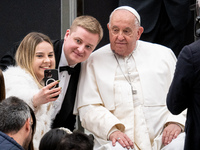 Pope Francis poses for a selfie with newlyweds at the end of the weekly general audience at Paul VI Hall in The Vatican, on December 11, 202...