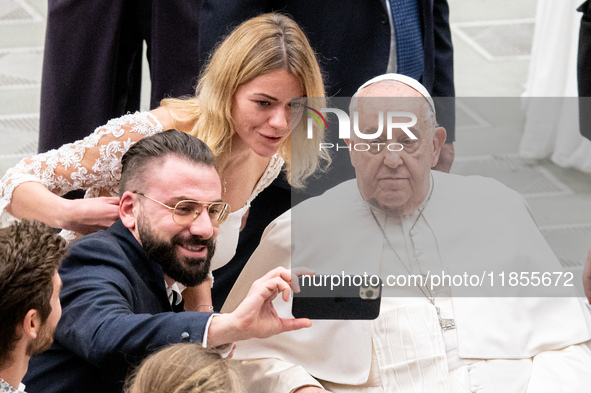 Pope Francis poses for a selfie with newlyweds at the end of the weekly general audience at Paul VI Hall in The Vatican, on December 11, 202...