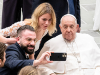 Pope Francis poses for a selfie with newlyweds at the end of the weekly general audience at Paul VI Hall in The Vatican, on December 11, 202...