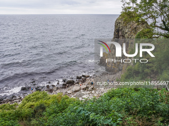 People visit Jons Kapel cliff near Hasle on Bornholm Island in Denmark on August 5, 2024. (