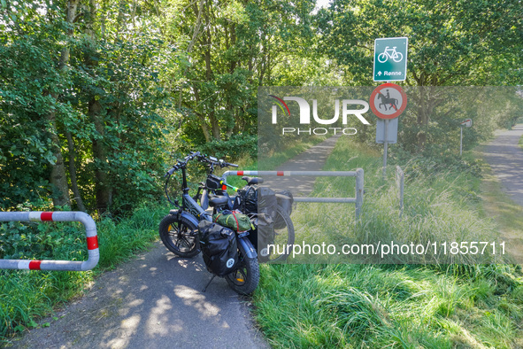 Two electric bikes park at the entrance to the bike lane in Ronne, Bornholm Island, Denmark, on August 6, 2024. 