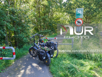 Two electric bikes park at the entrance to the bike lane in Ronne, Bornholm Island, Denmark, on August 6, 2024. (