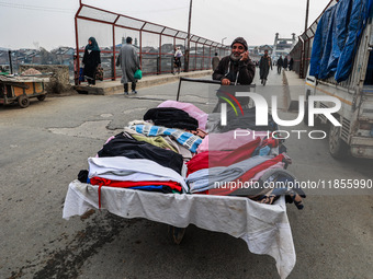 A man sells woolen clothes on a cold day in Sopore, Jammu and Kashmir, India, on December 11, 2024. (